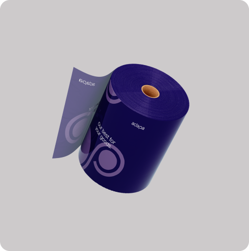 A large roll of dark purple flexible packaging film with a brown cardboard core, floating at an angle against a light gray background. The glossy material features light purple circular patterns along with the white adapa brand logo and the slogan "Our best for your goods.