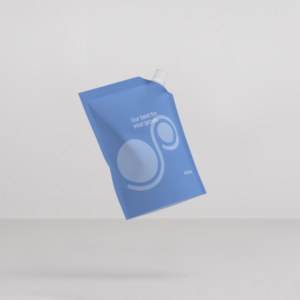 web-optimised-adapa_pouch with spout_light blue A light blue flexible pouch with a white corner spout and cap floating tilted against a light gray background. The front of the pouch displays light gray circular graphics, the white slogan "Our best for your goods.", and the white "adapa" brand logo near the lower-right corner.